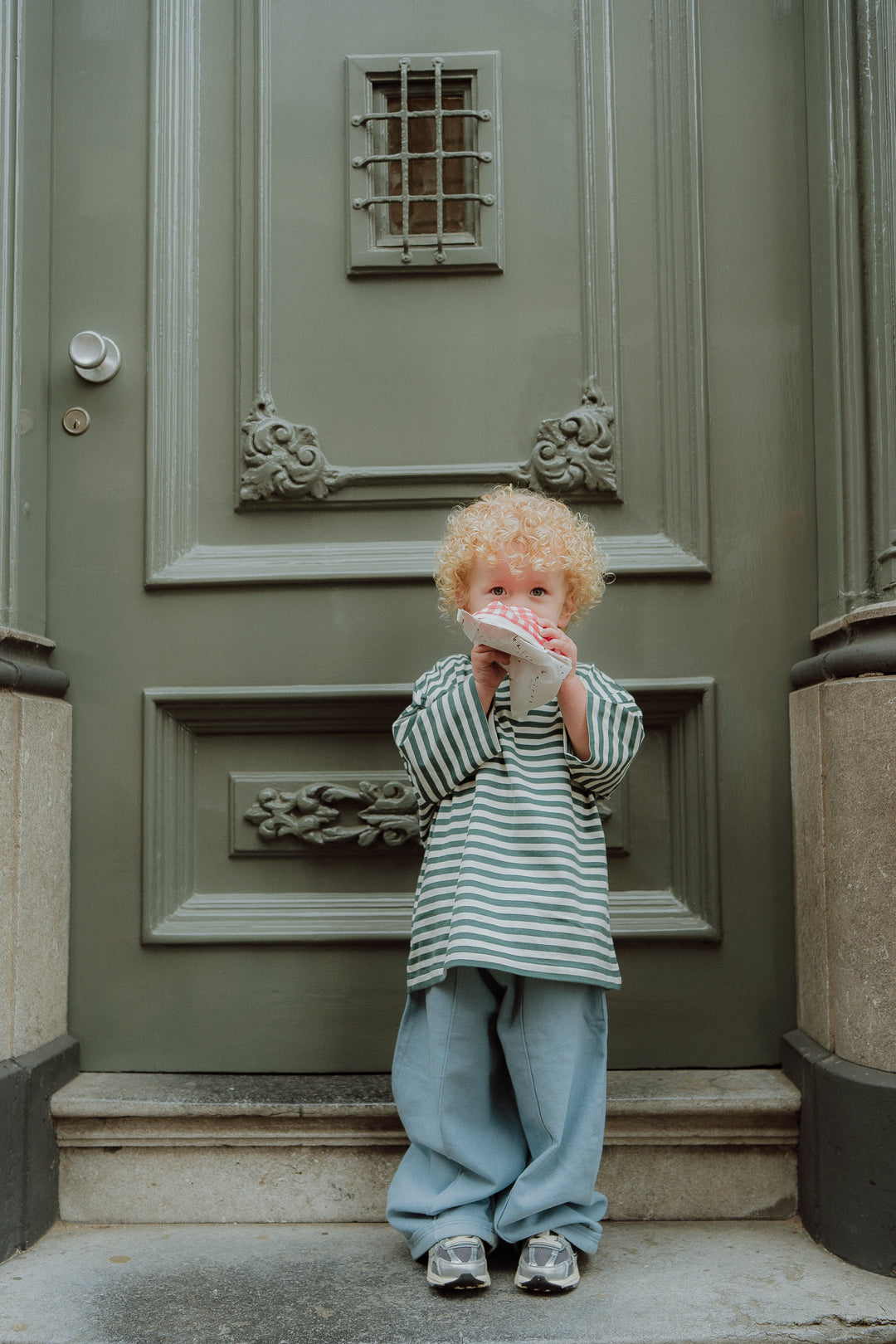 Kids fashion outfit with green striped oversized tee and loose blue pants