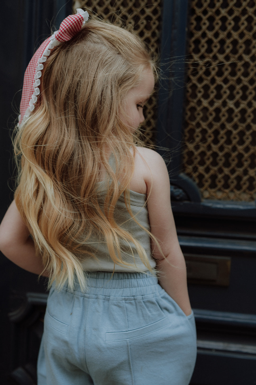 Girl wearing light blue pants and neutral sleeveless top in casual lifestyle setting