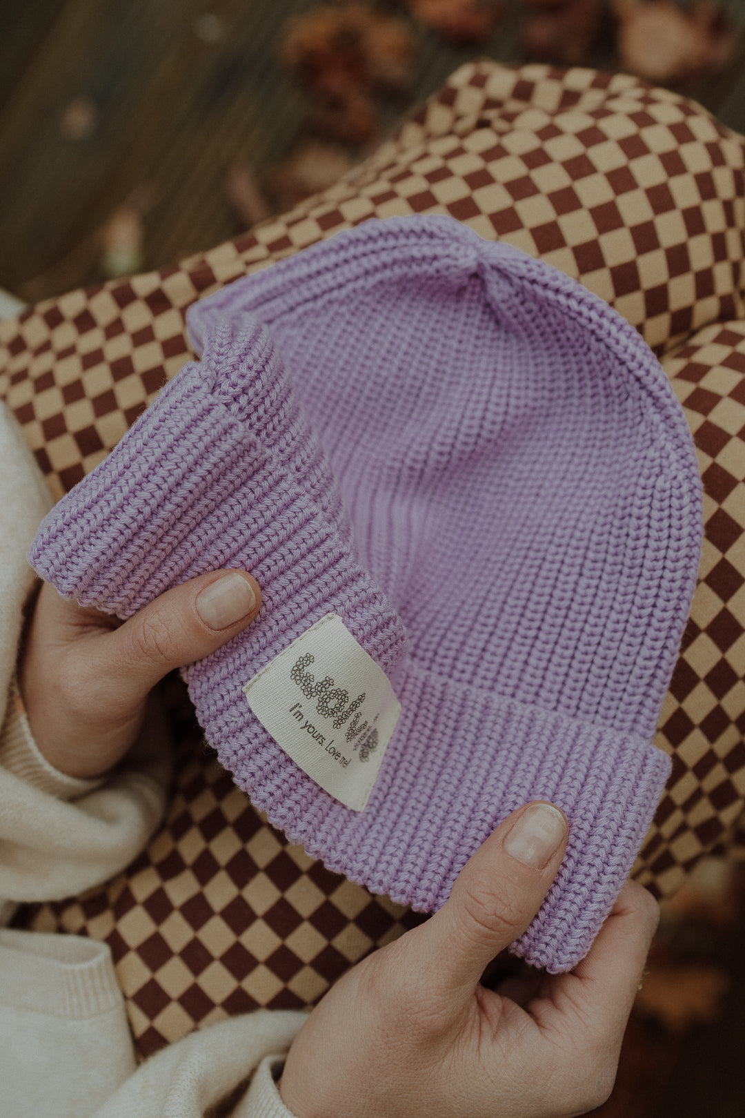 Close-up of a lilac knit beanie with Wolvie label