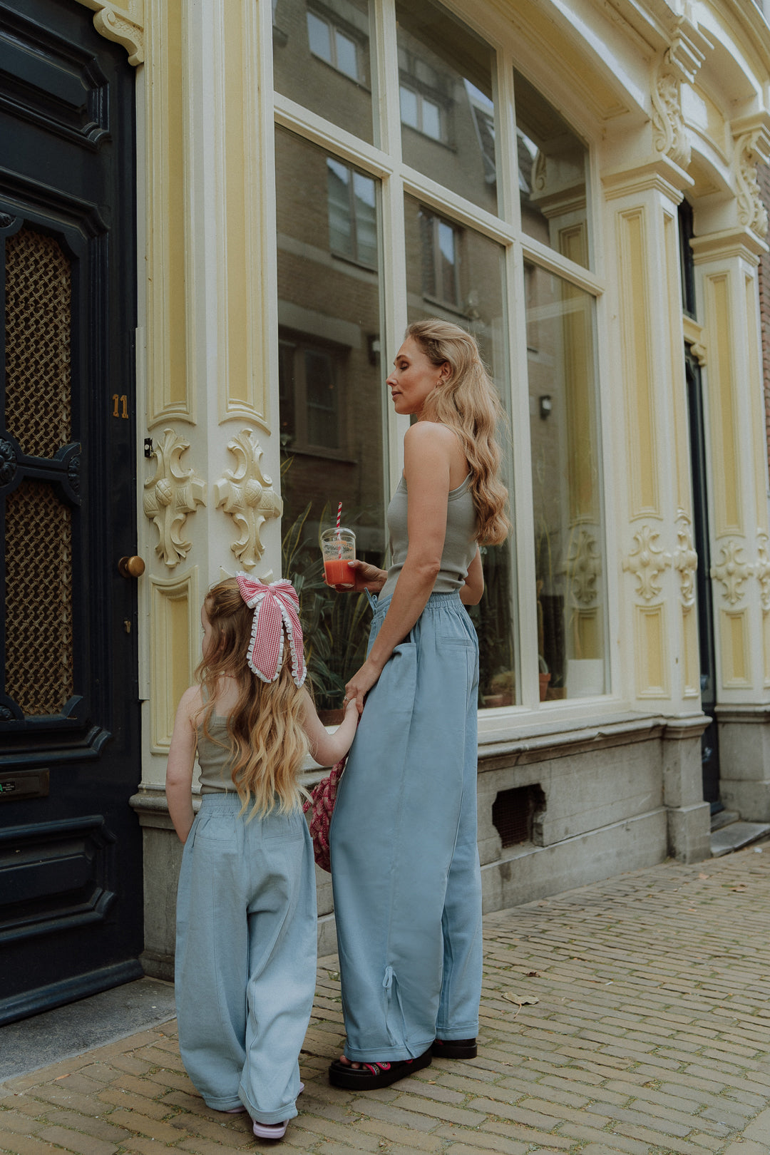 Matching mom and daughter outfit with blue pants in street style setting