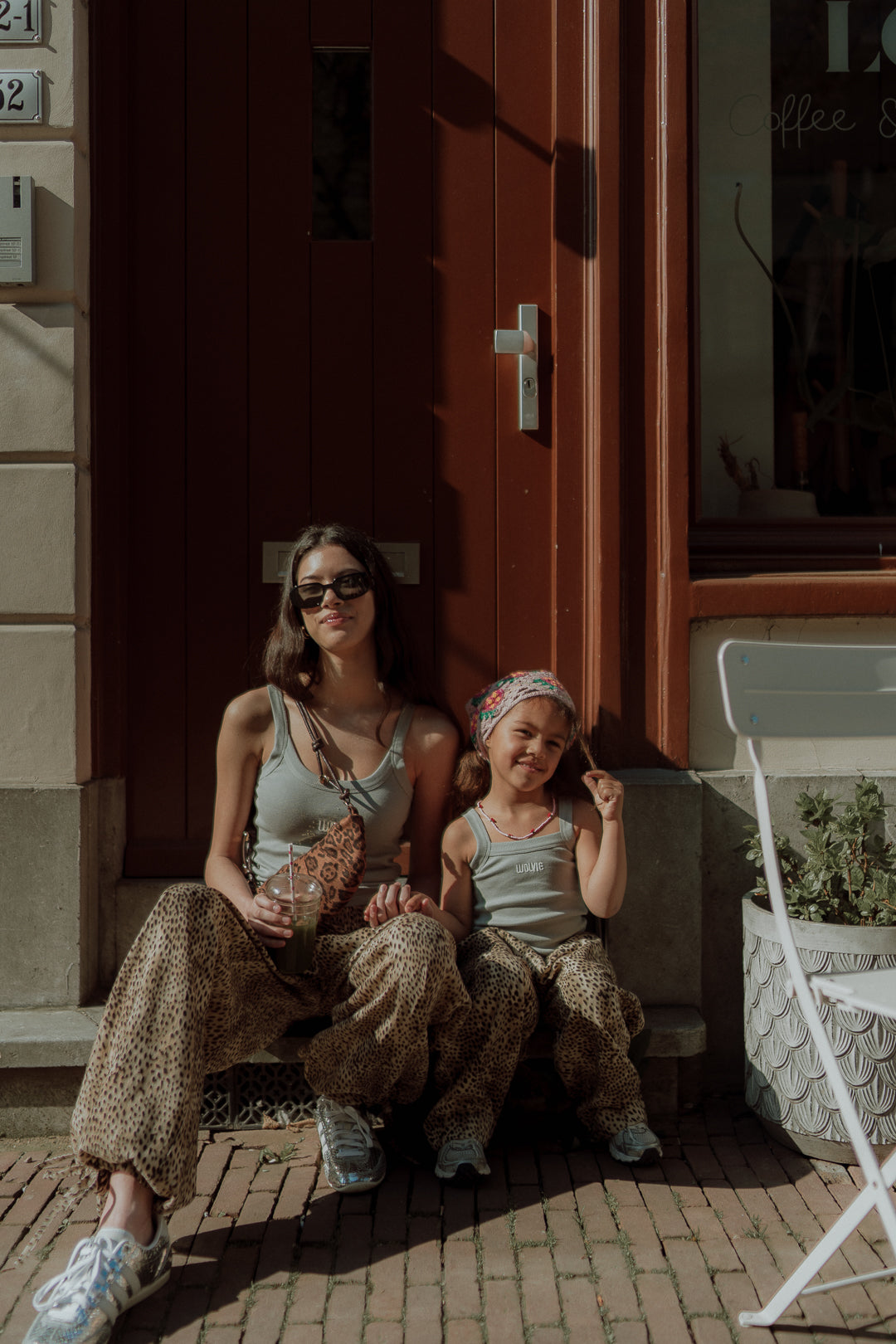Mother and daughter wearing matching leopard print pants and neutral tops
