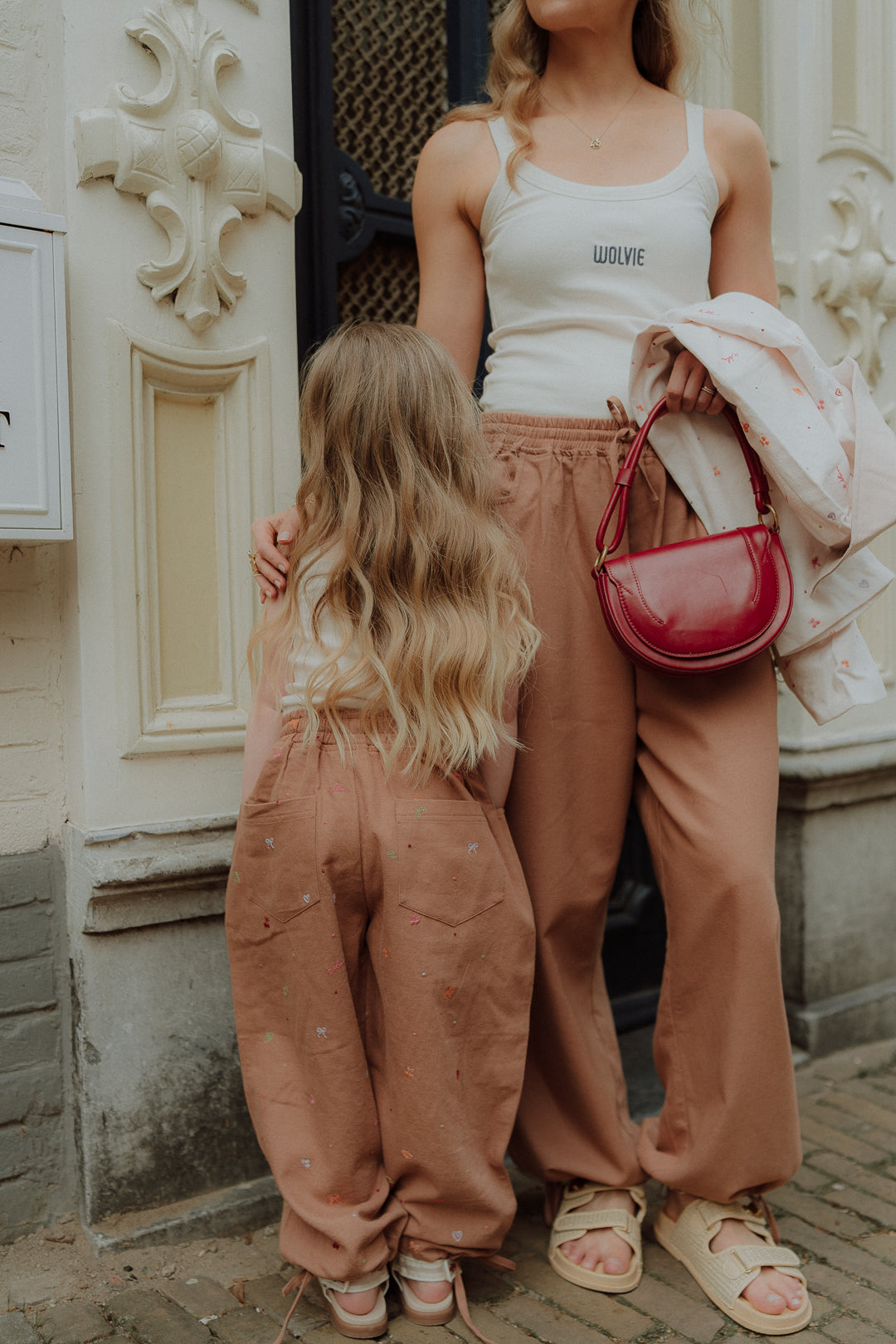 Matching mom and daughter outfit with neutral wide leg pants and white tops