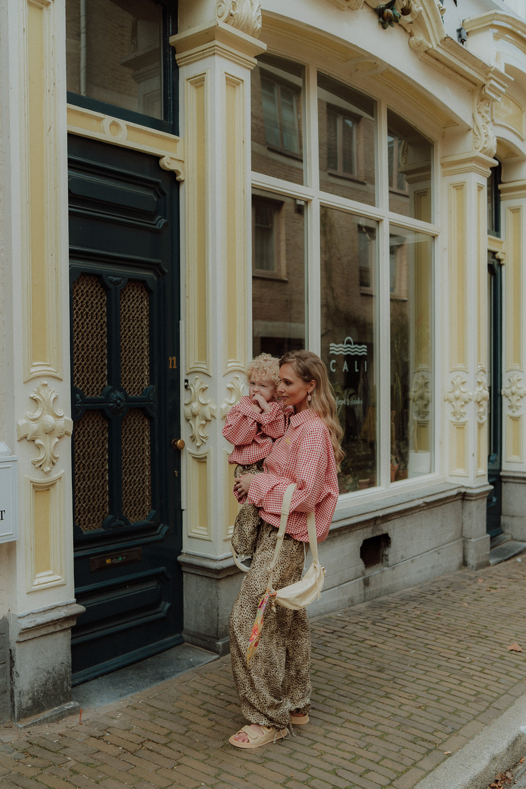 Mom and child in matching outfit walking on street full body lifestyle fashion