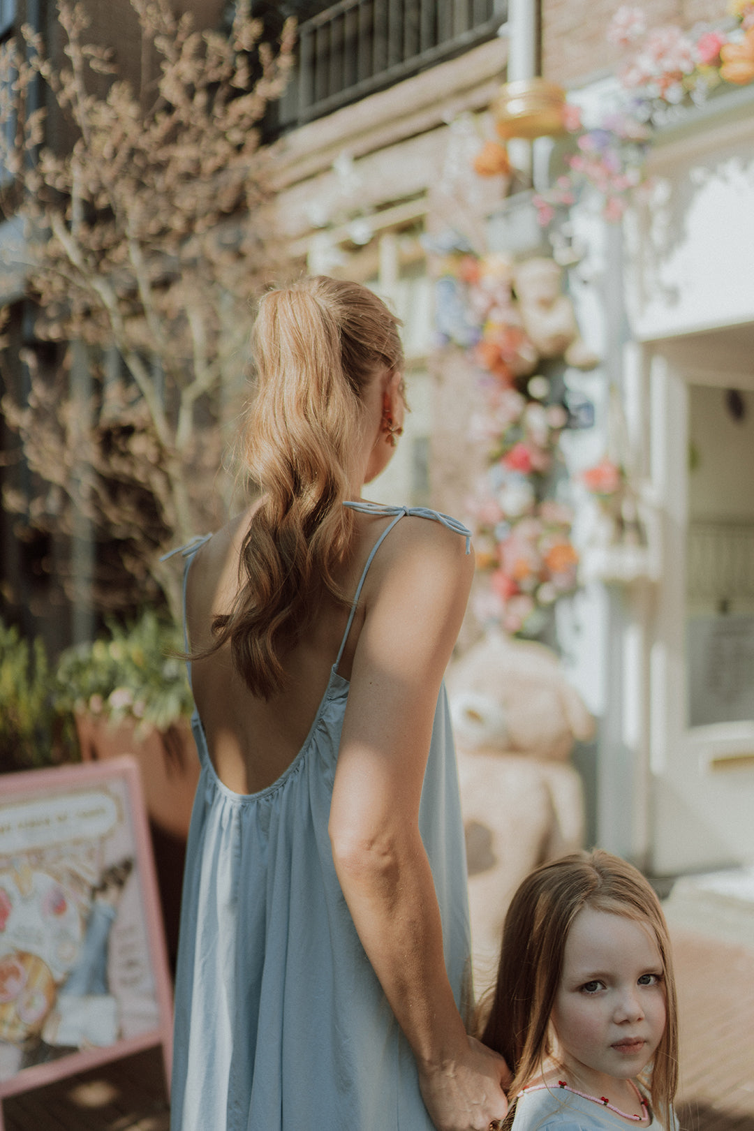 Mother and daughter wearing matching light blue summer dresses =