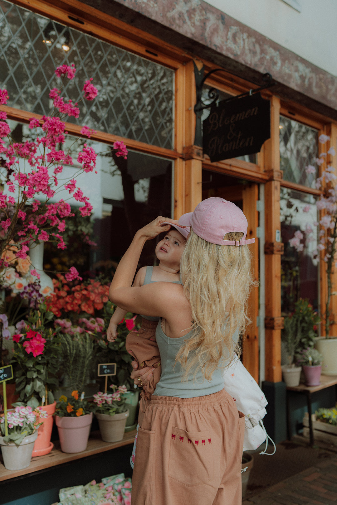 Mom outfit with pink cap outside flower shop summer lifestyle