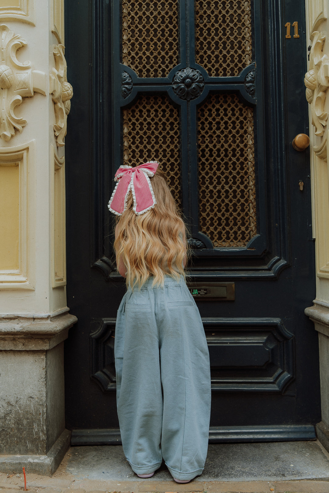 Kids outfit with blue wide pants and red gingham bow from Wolvie