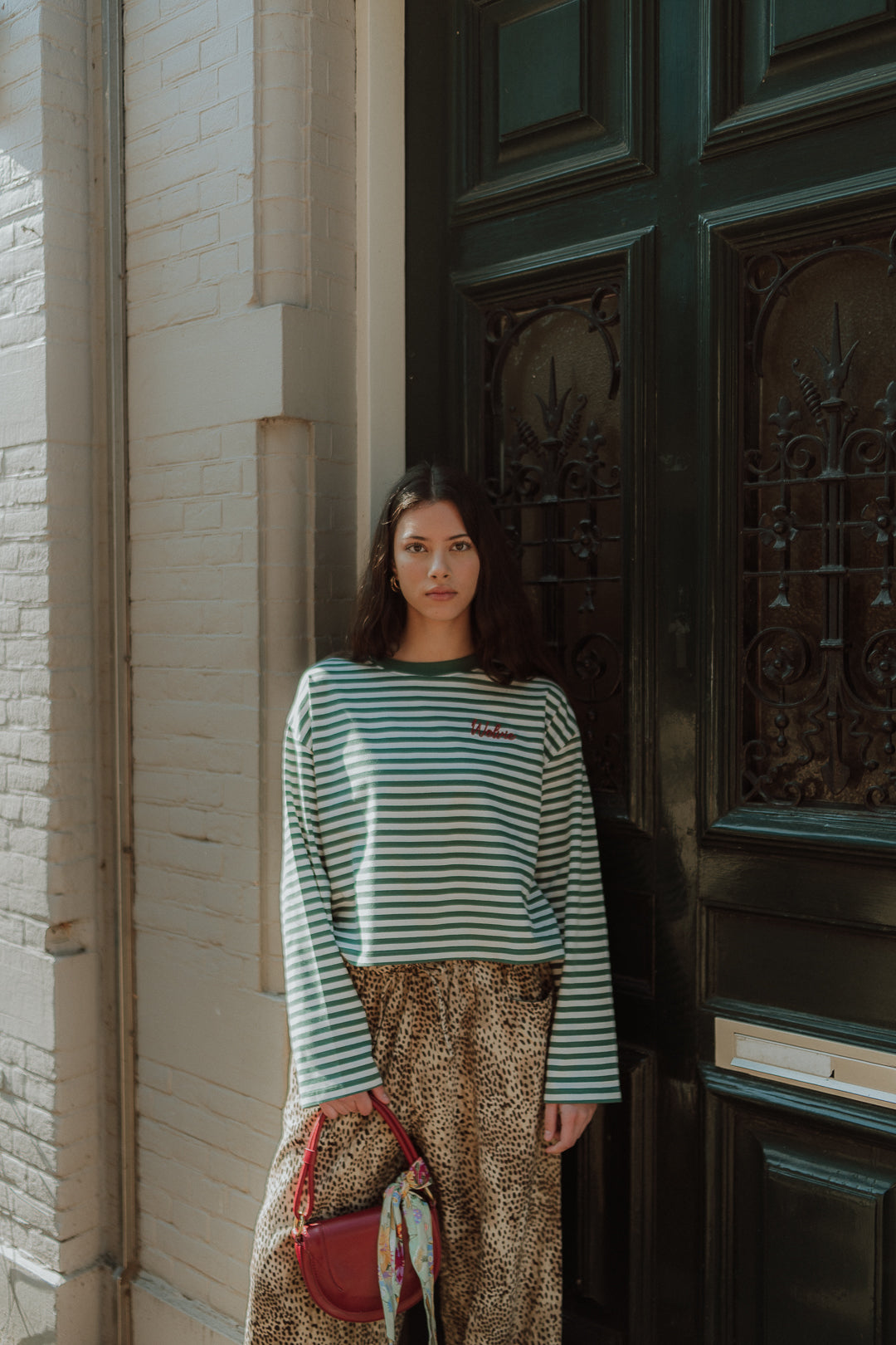 Woman wearing green striped long sleeve shirt with leopard print pants