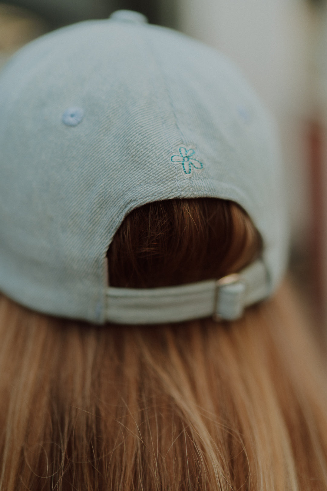 Close-up detail of a baby blue cap with embroidered flower detail from the Wolvie collection.