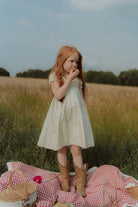 Girl wearing a light summer dress and cowboy boots