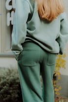 Back view of a person wearing a green oversized lounge set outdoors.