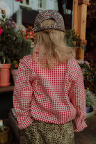Girl wearing red checkered shirt with leopard print cap and casual outfit styling