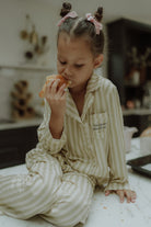 Child wearing beige striped matching pajama set