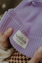 Close-up detail of a lilac knitted beanie with Wolvie label