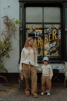 Mom and child wearing matching checker pants and soft neutral knitwear 