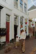 Mom and child wearing matching checker pants during a cozy autumn walk