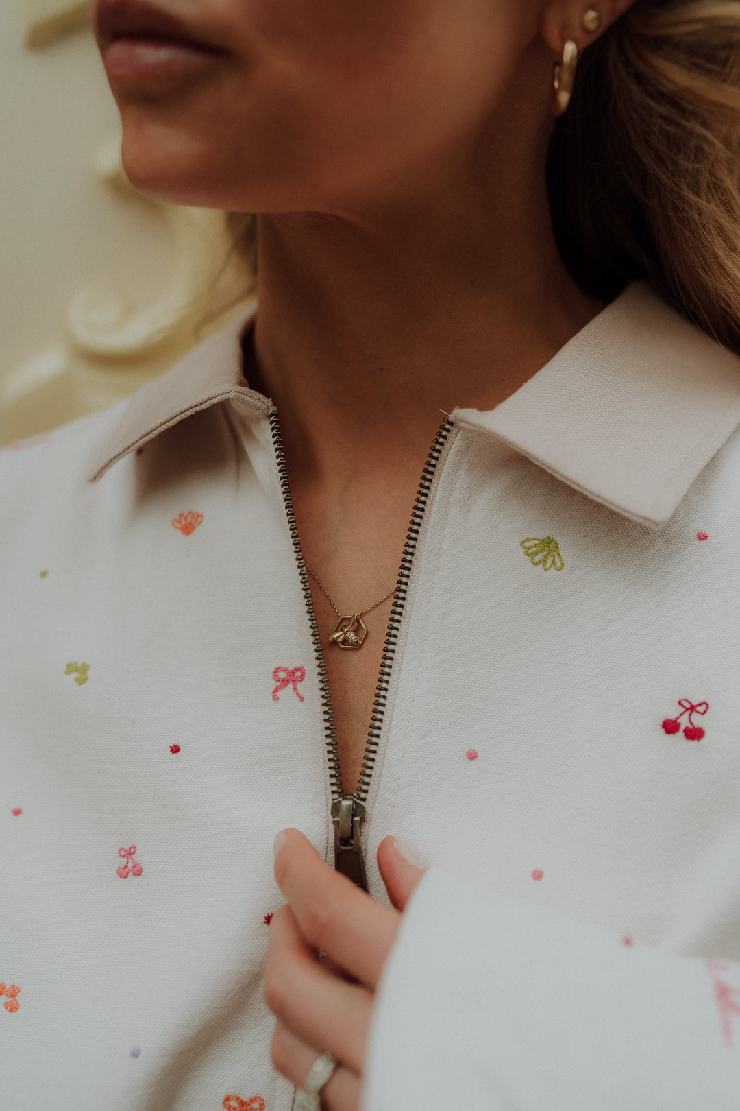 Woman wearing matching clothes cream zip top with colorful embroidered details in a comfy oversized outfit