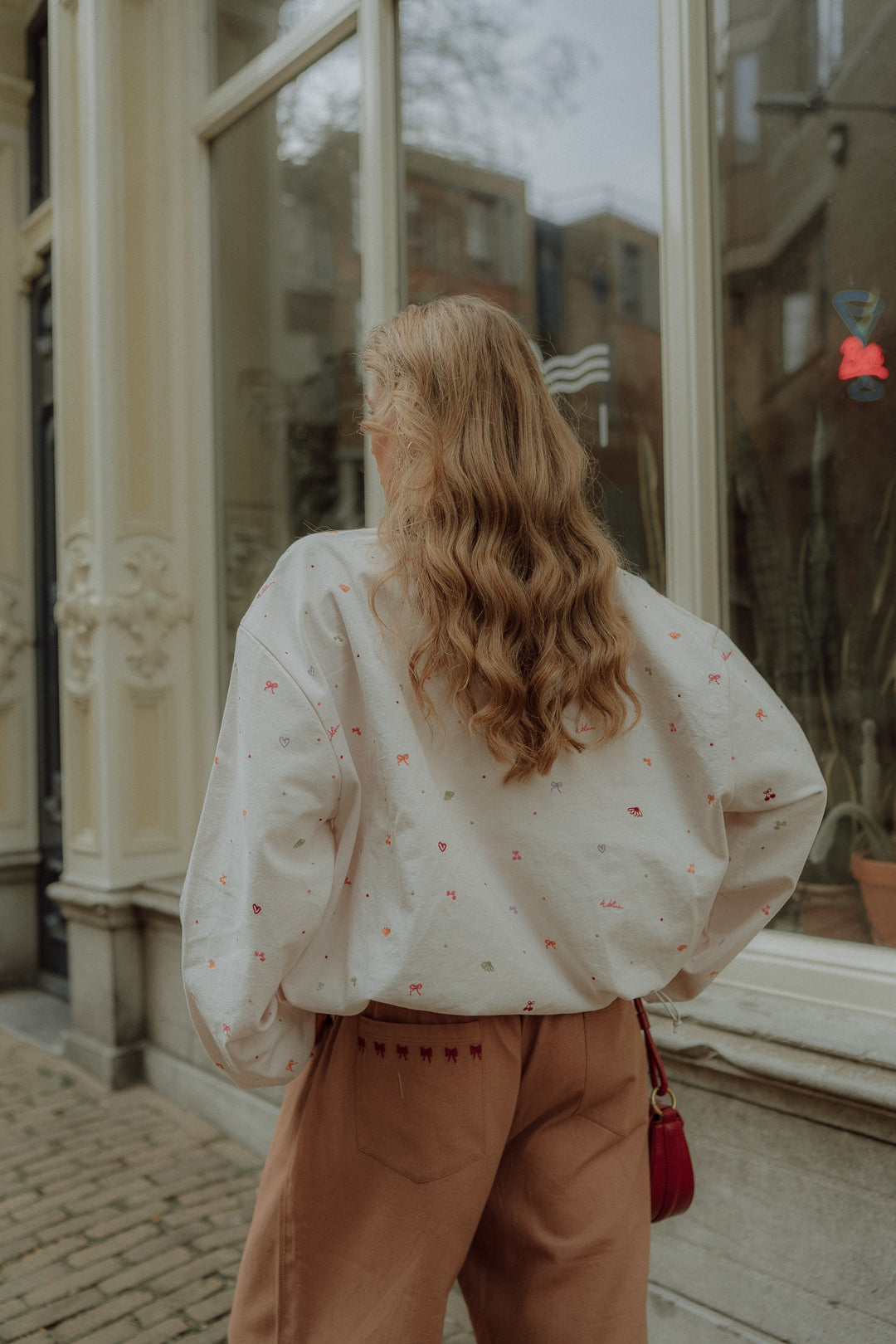 Woman wearing matching clothes with an oversized sweater and neutral wide leg pants in a comfy stylish outfit