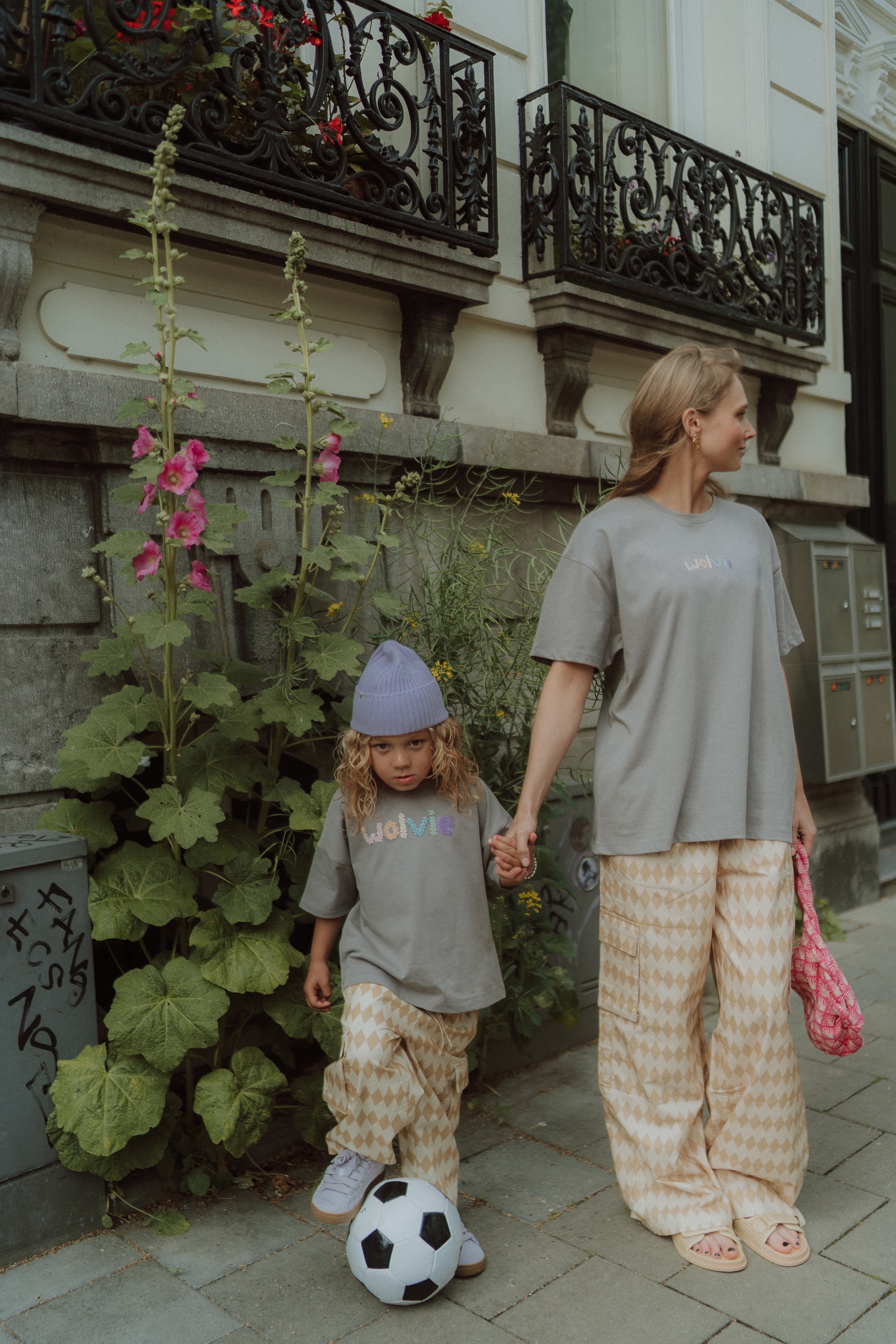 Woman and child wearing matching grey t-shirts and printed pants