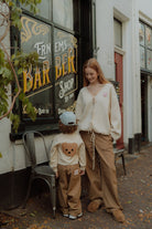 Mom and child wearing matching checker pants and soft knitwear