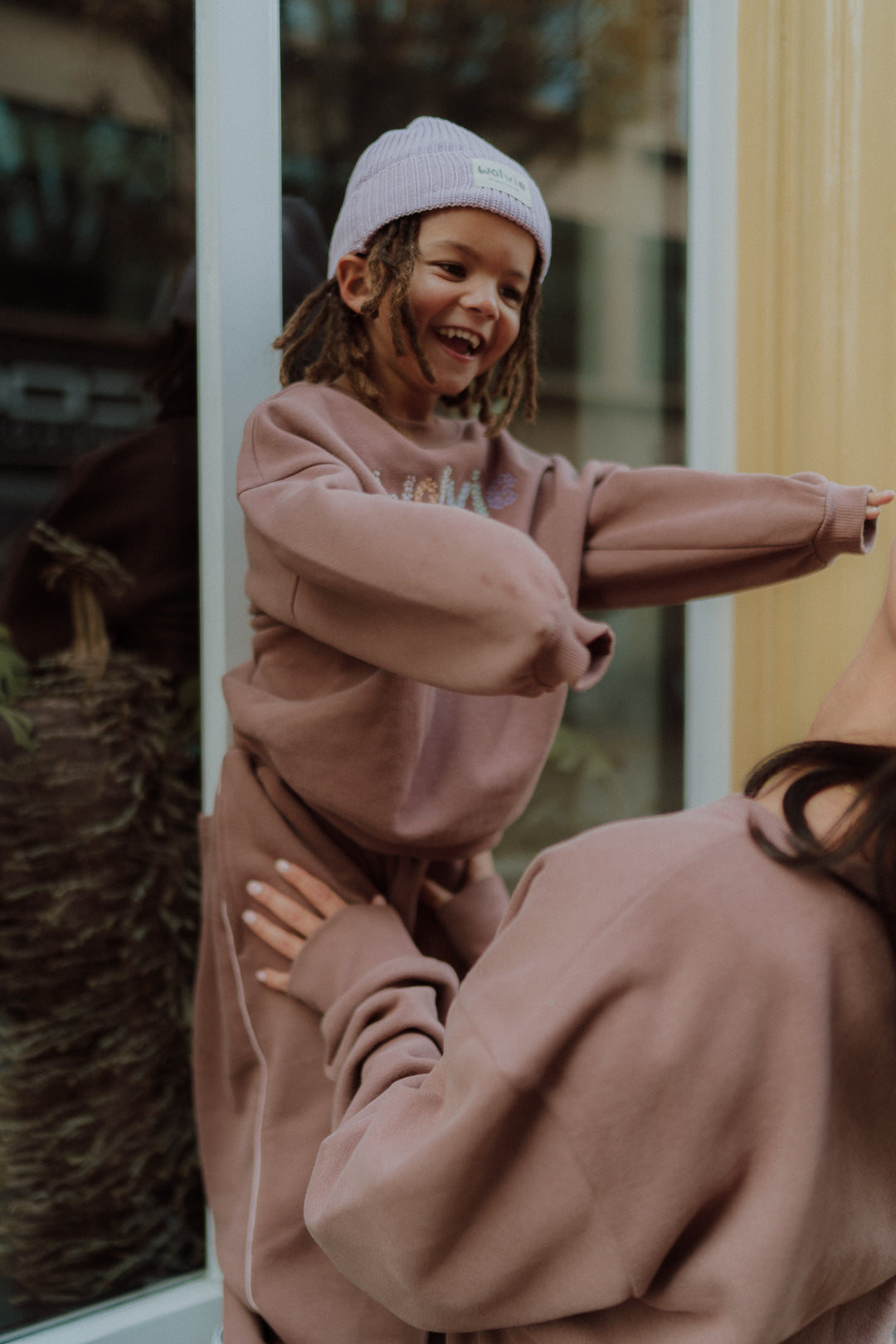 Child wearing a soft mauve lounge set while playing with mom.
