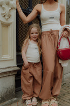 Matching mom and daughter outfit with white tank tops and brown wide leg pants