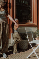 Matching mom and daughter outfit with grey tops and leopard print pants outdoors