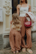 Matching mom and daughter outfit with neutral wide leg pants and white tops