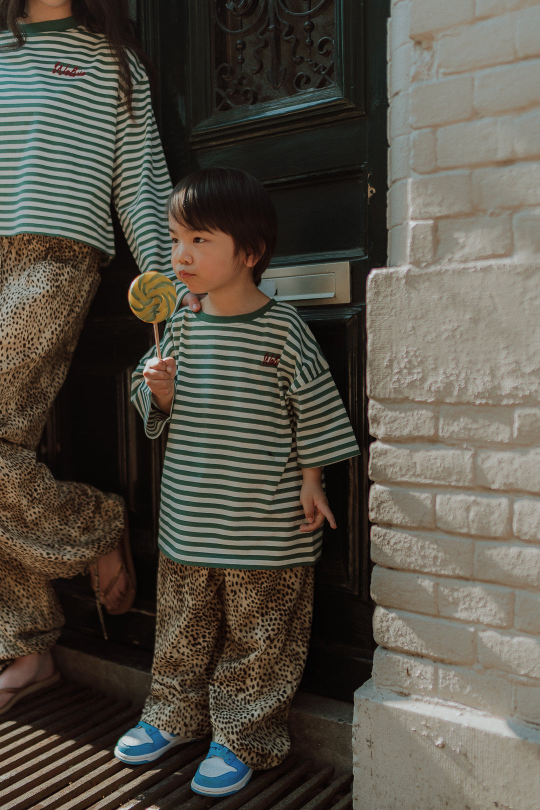 Child wearing a striped shirt and leopard print pants matching with mom outfit by Wolvie