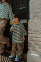 Child wearing a striped shirt and leopard print pants matching with mom outfit by Wolvie