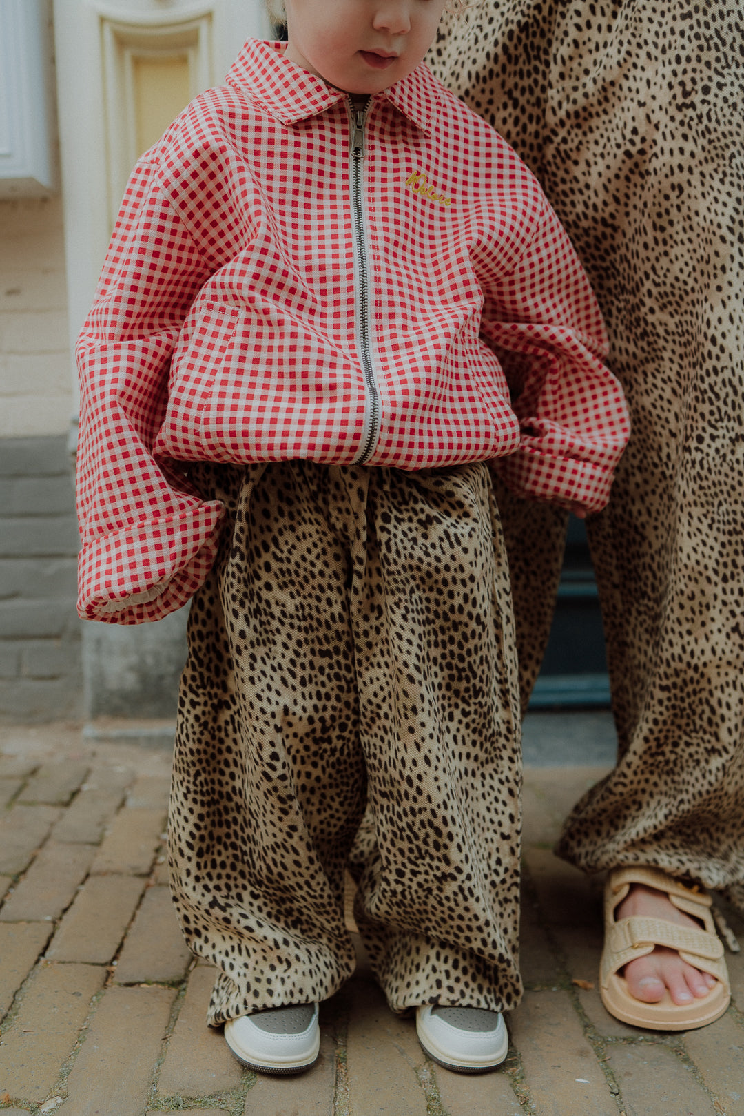 Matching mom and kids outfit with leopard print pants and red gingham jacket for kids