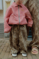 Matching mom and kids outfit with leopard print pants and red gingham jacket for kids
