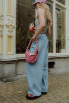 Matching mom outfit blue wide leg pants street style with pink bag lifestyle look.
