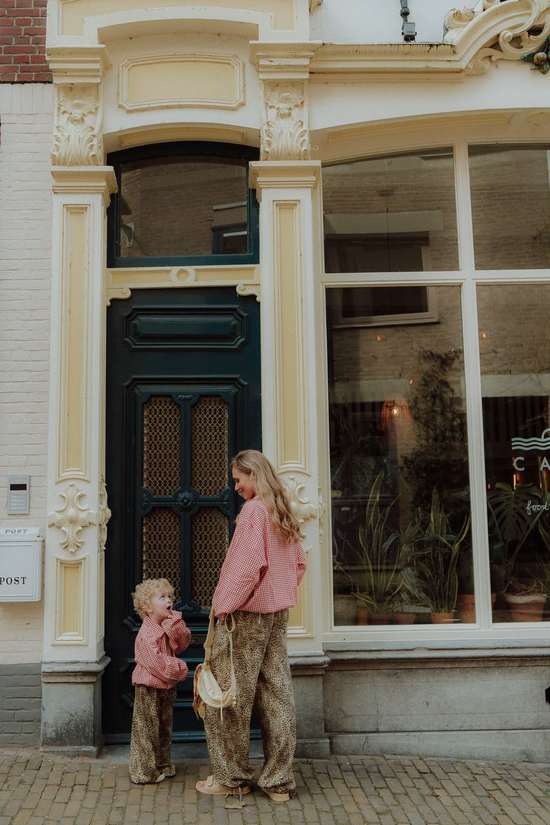 Matching mom and toddler outfit in red gingham and leopard pants outdoor streetstyle