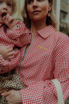 Mom and child in matching red checkered outfit stylish close up