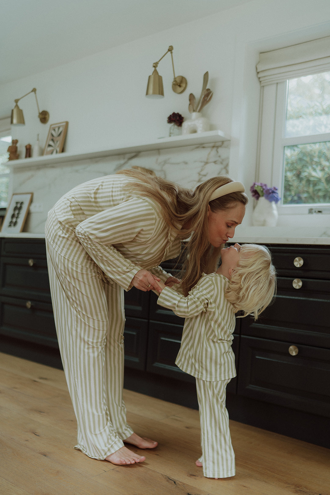 Mother and child wearing matching beige striped pajamas