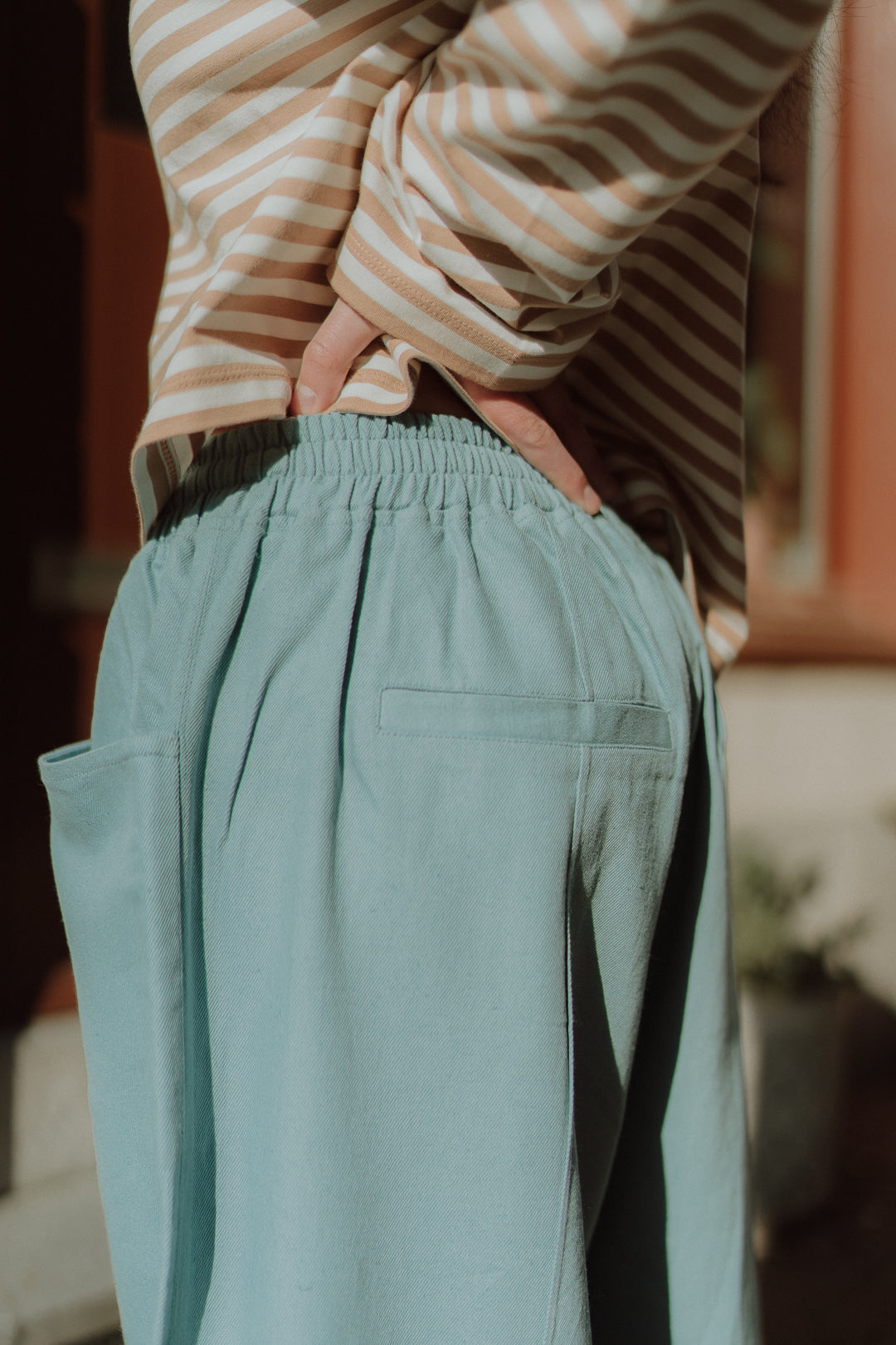 Trendy  fashion close up of loose fit blue pants and striped shirt