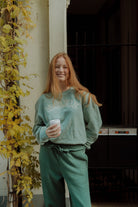Woman wearing an oversized green sweatshirt and matching sweatpants