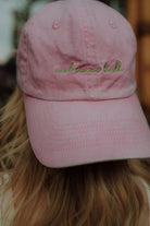 Close up of pink baseball cap with cool kids club embroidery
