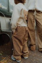 Matching kids checkered pants outfit with bear sweater by Wolvie Women & Kids.  