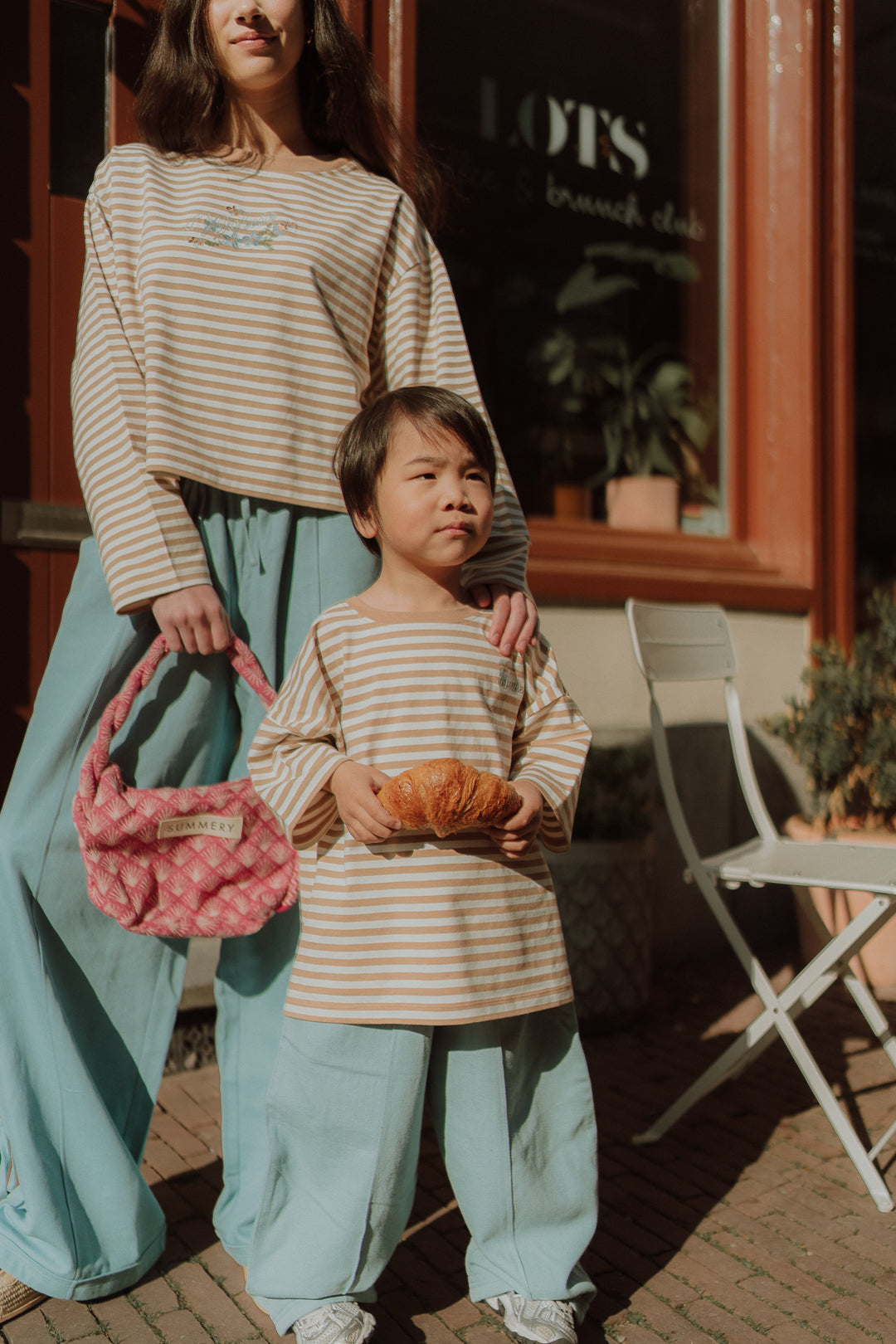 Matching striped WOLVIE outfits for mom and child with relaxed blue pants and neutral tones