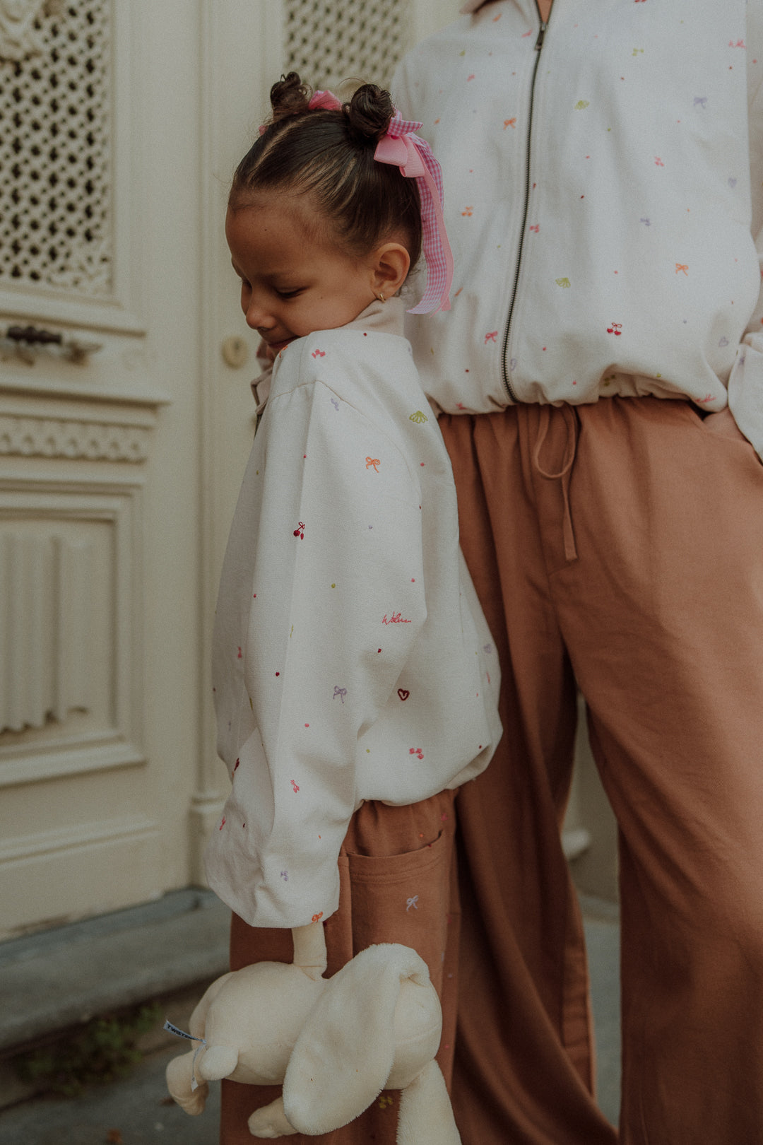 Mom and child wearing matching camel pants and embroidered blouse from Wolvie SS26 collection.