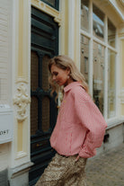 Woman wearing red gingham blouse with leopard print pants in street style setting