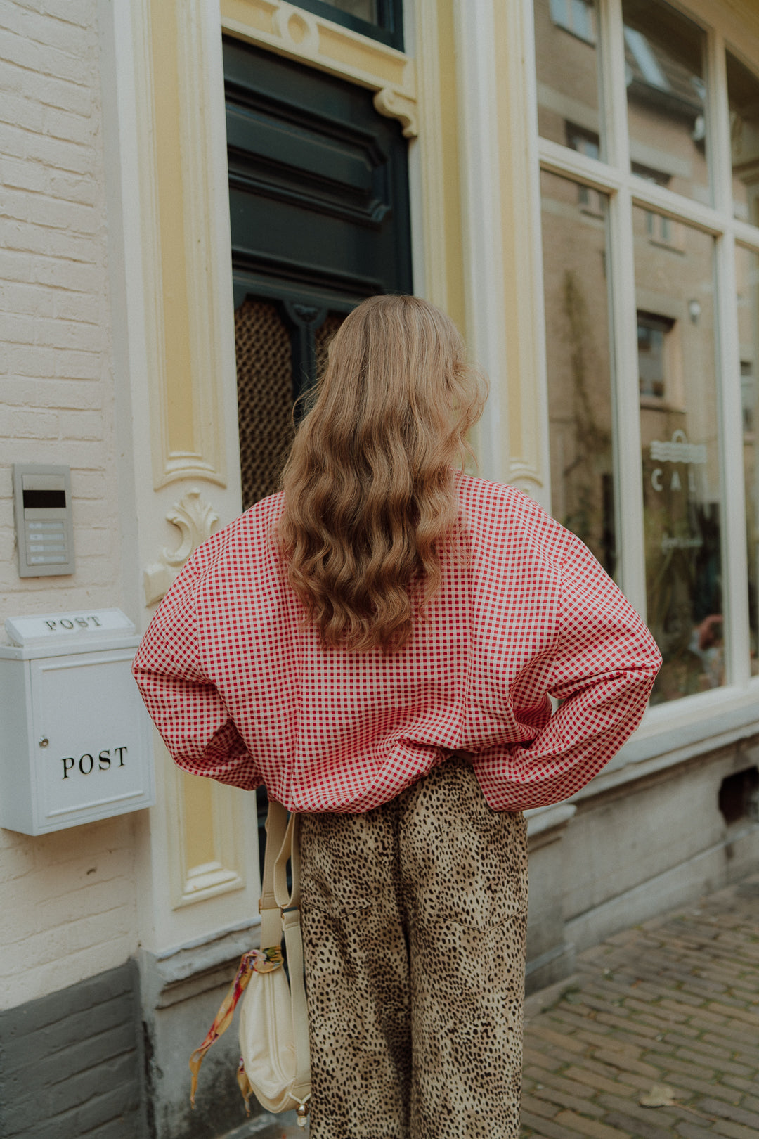 Women street style outfit with red checkered shirt and leopard trousers