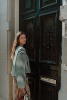 Woman wearing a green striped oversized top with leopard print pants in a trendy matching outfit.