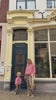 Mother and child wearing matching WOLVIE sweaters and leopard print pants in front of store.